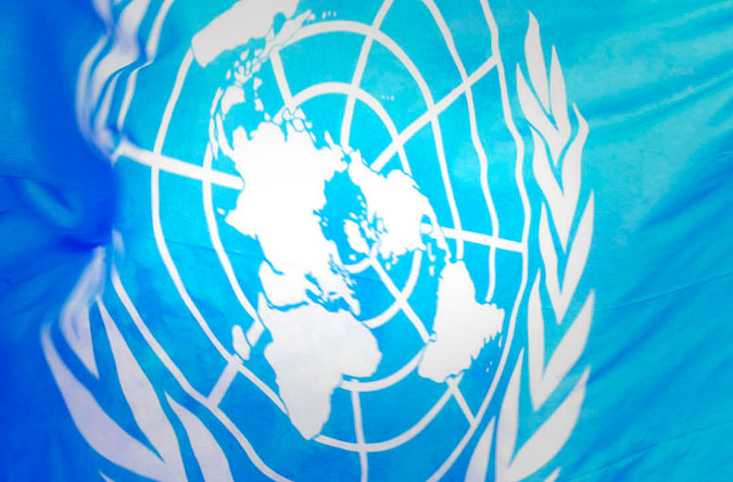 FNs logga i vitt på en blå bakgrund.