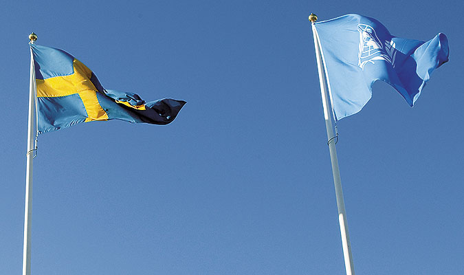 En svensk flagga vajar bredvid en FN-flagga