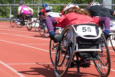 Atleter i rullstol tävlar i ett lopp på en löparbana.