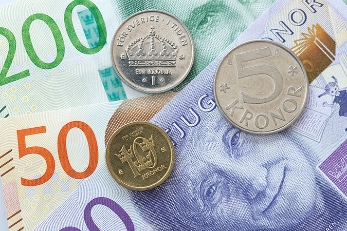 En närbild på svenska sedlar och mynt.