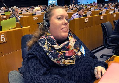Karolina Celinska sitter i parlamentssalen med hörlurar på.