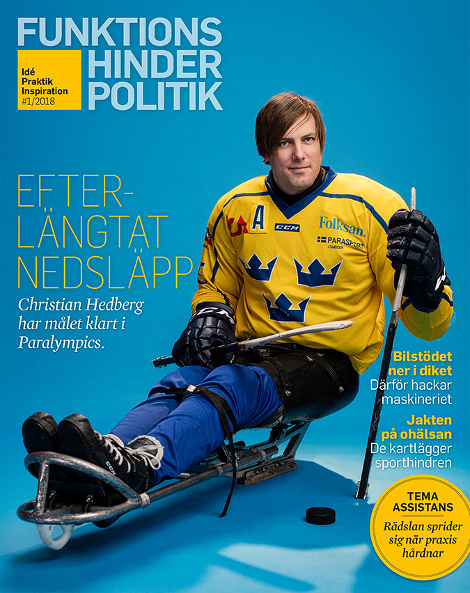 En paraishockeyspekare siotter i en kälke iförd svensk landslagsdräkt. I de handskklädda händerna håller han hockeyklubbor.