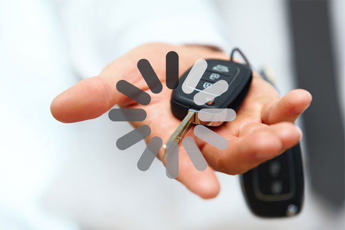 En hand håller fram ett par bilnycklar. Ovanpå bilden ligger ett markering som på en dator eller mobiltelefon brukar indikera väntan medan bilden laddas.