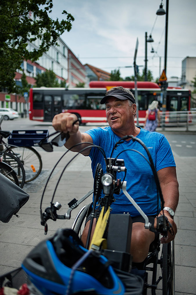 Björn Billung i gatumiljö. I bakgrunden ser man en röd linjebuss och till vänster ett cykelställ med några parkerade cyklar. 