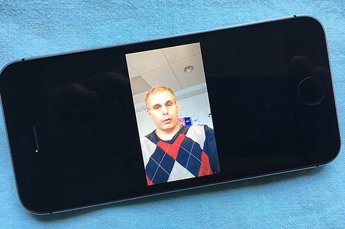 En bild på en mobiltelefon där DHRs ordförande Rasmus Isaksson syns på skärmen.