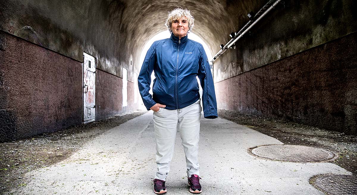 Bild på Åsa Llinares Norlin. Hon står i vad som ser ut att vara en tunnel. Bakom henne skymtar en ljus öppning.