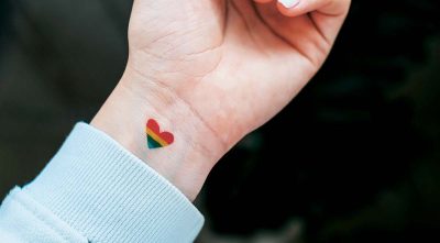 Ett hjärta i regnbågens färgspektra är målat på en handled.
