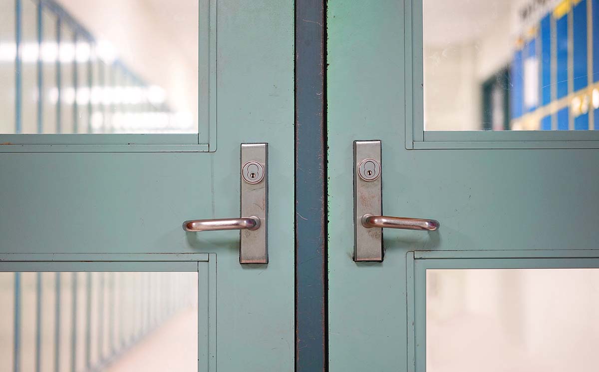 En stängd dubbeldörr i en skolkorridor.
