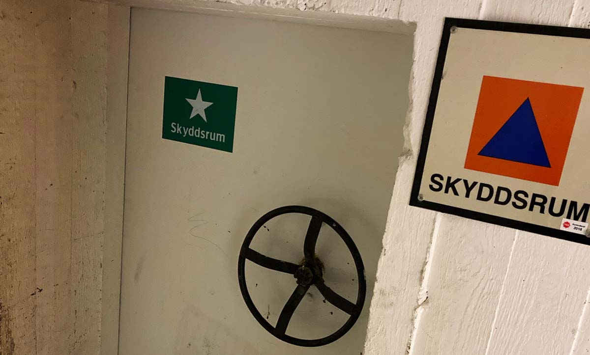 En dörr till ett skyddsrum, med en skylt bredvid där det står skyddsrum.