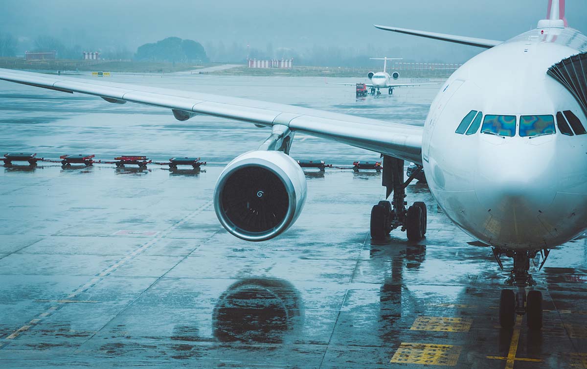 Bild från en flygplats i ren. Ett flygplan i förgrunden och ett lite mindre längre bort.