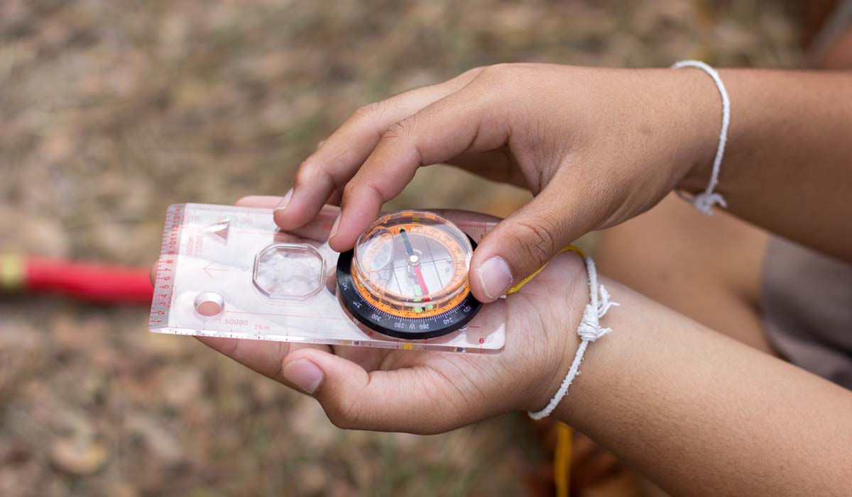 Ett par händer håll i en kompass.