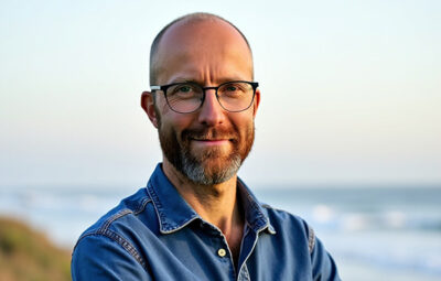 Porträtt av en korthårig man med glasögon och skägg.