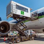 En lift fö personer med nedsatt rörelseförmåga står i uppfällt läge bredvid ett flygplan pop en flygplats.