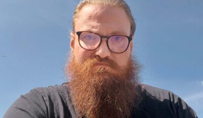 Porträttbild av en man med skägg och glasögon.